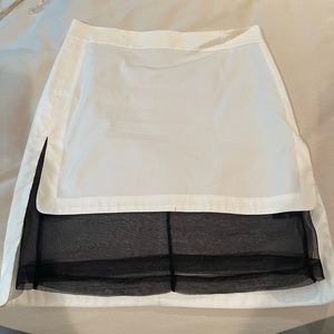 White mini skirt with black sheer front layer.